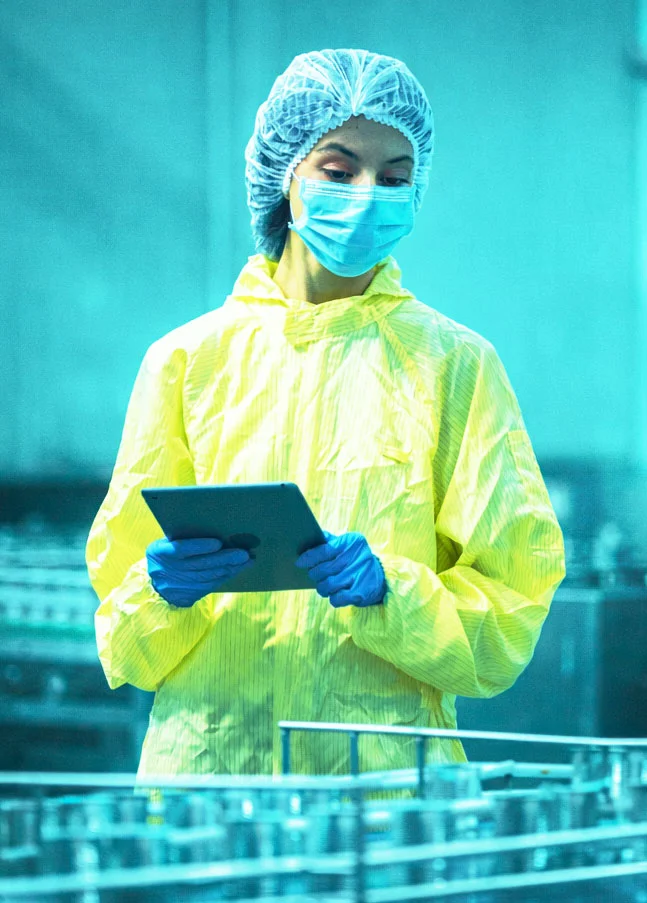 Mitarbeiterin überwacht Produktionsanlage per Tablet als Beispiel für Abweichungsmanagement und CAPA im SAP Qualitätsmanagement.