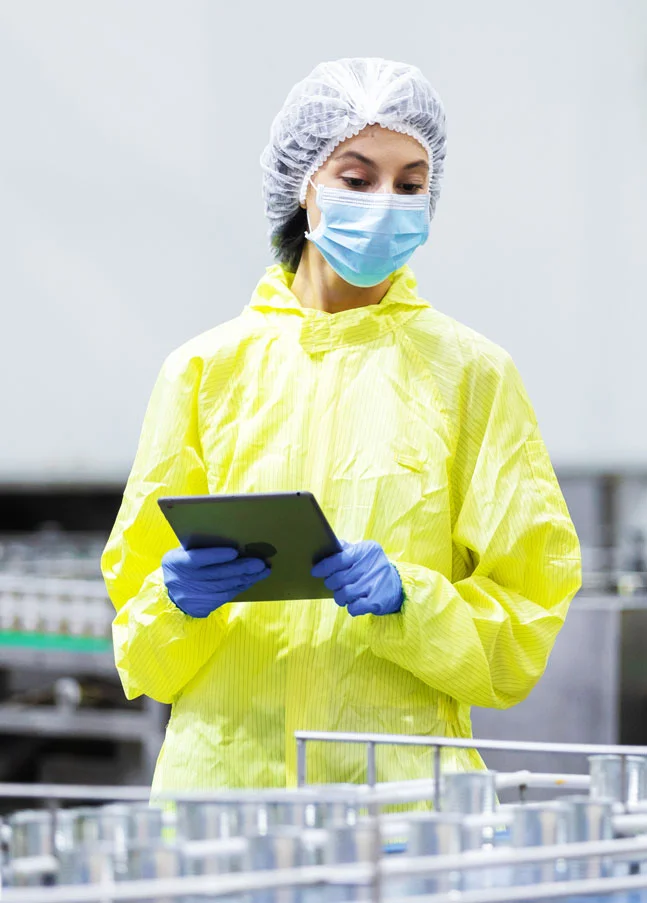Employee monitoring a production line via tablet as an example of deviation management and CAPA in SAP Quality Management.