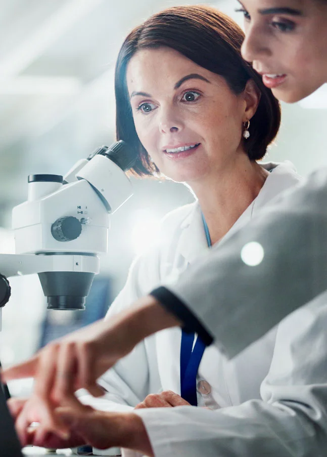 Wissenschaftlerinnen prüfen Labordaten am Computer – Beispiel für GxP-Compliance, CSV-Audits und Data-Integrity-Kontrollen.