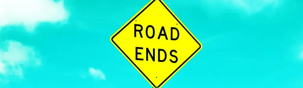Gelbes Verkehrsschild mit der Aufschrift „Road Ends“ vor blauem Himmel – als Symbol für das bevorstehende Support-Ende von SAP QIM.