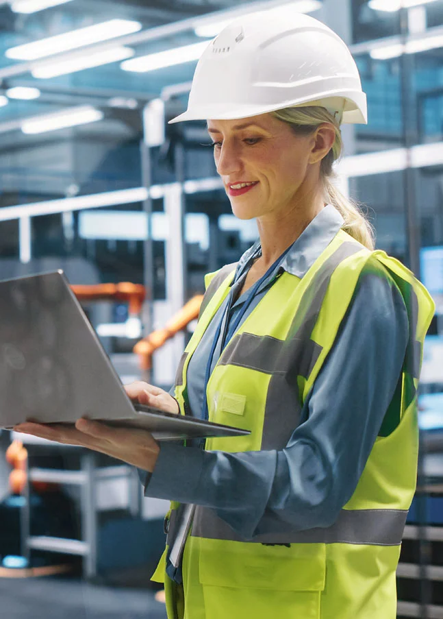 Engineer using a laptop for quality control on a production line with SAP Quality Management